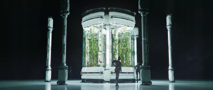 A futuristic sci-fi structure featuring a transparent cylindrical chamber with lush greenery, surrounded by sleek pillars, creating a striking HD desktop wallpaper and background.