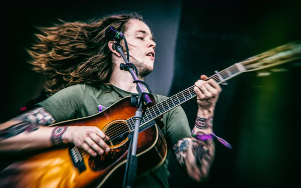 Dynamic HD wallpaper featuring a passionate guitarist in mid-performance, capturing the energy and emotion of live music.