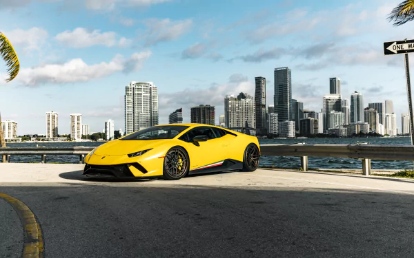 Yellow Lamborghini Huracan Performante supercar parked by the waterfront with a city skyline in the background, captured in high-resolution 4K Ultra HD.
