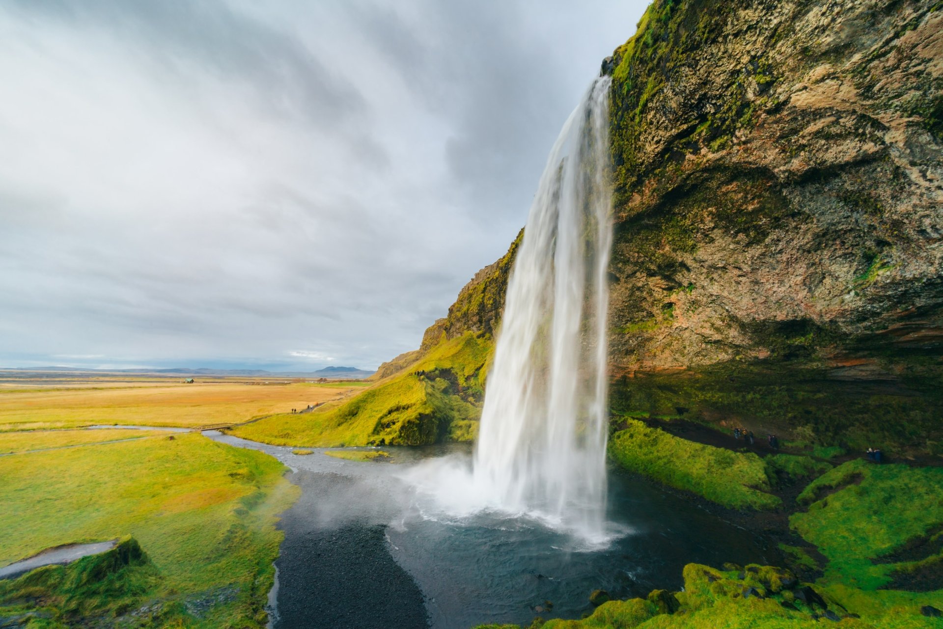 Seljalandsfoss waterfall cascades beside a cliff in Iceland's natural landscape, captured in stunning 4K Ultra HD for a vibrant PC desktop wallpaper.