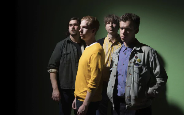 HD desktop wallpaper featuring a group of four members standing together with a moody green background, tagged with Parquet Courts.