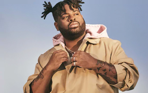 HD desktop wallpaper featuring a person in a pink hoodie and beige jacket against a blue sky background.