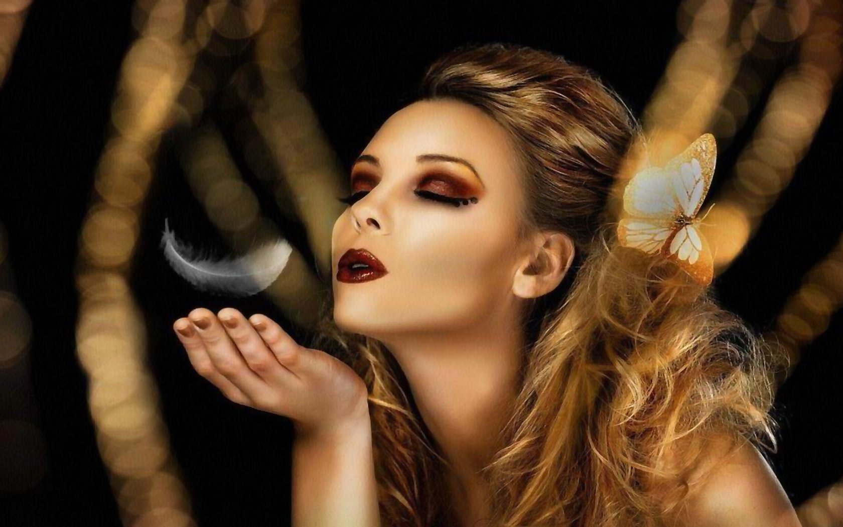 A fantasy-themed HD desktop wallpaper featuring a woman with striking makeup, softly blowing a feather with butterfly accents, set against a blurred golden background.