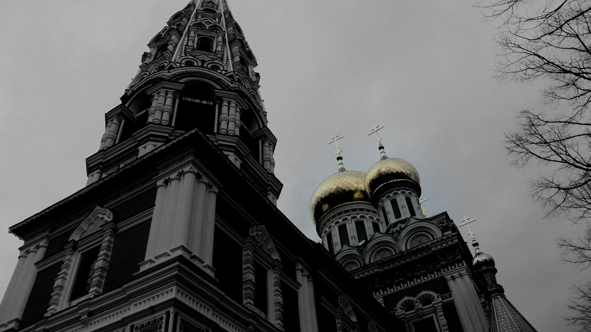 A dramatic black and white 4K Ultra HD image of a historic church with ornate domes and spires, showcasing intricate man-made architecture against a cloudy sky.