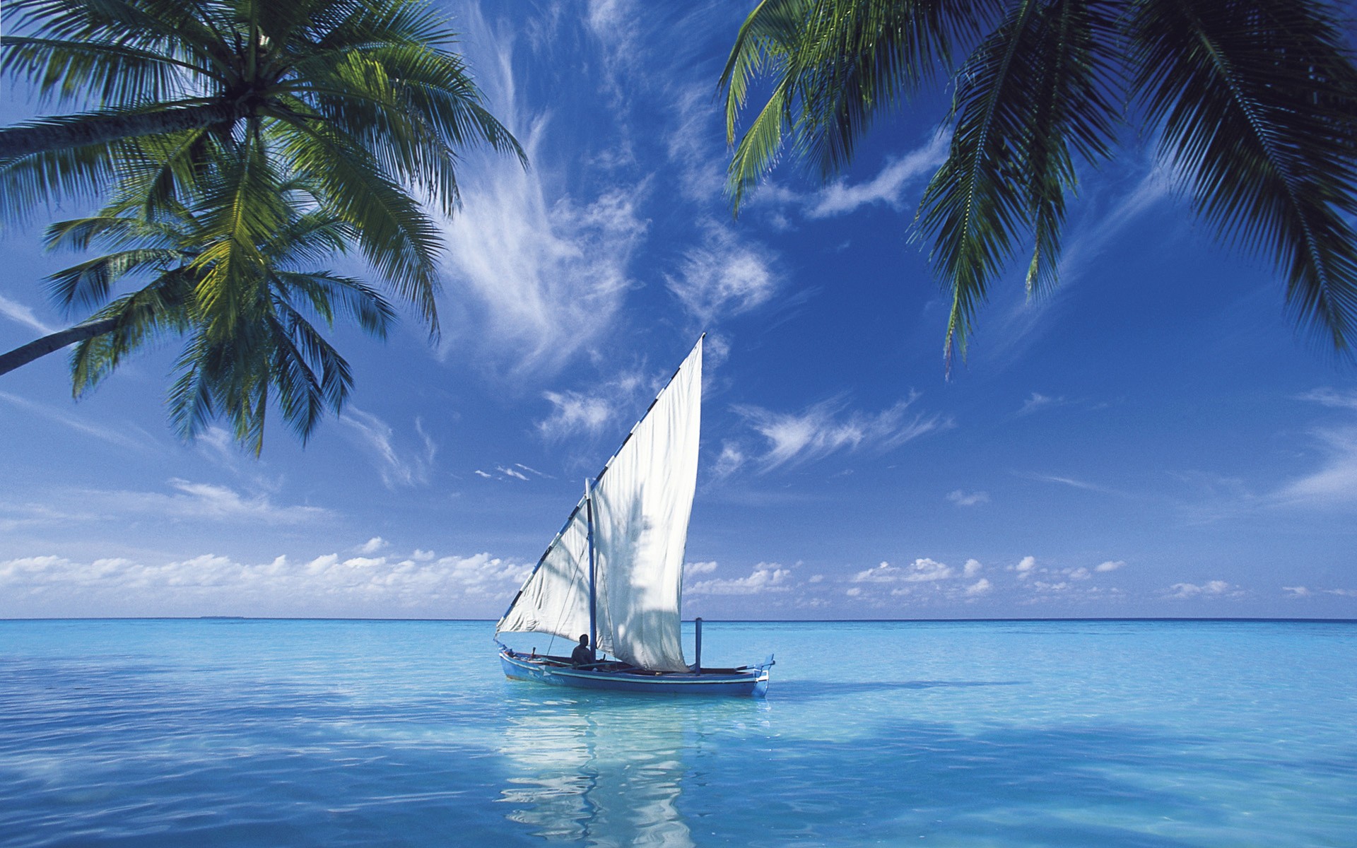 A serene boat scene on the water, surrounded by nature and a clear blue sky.
