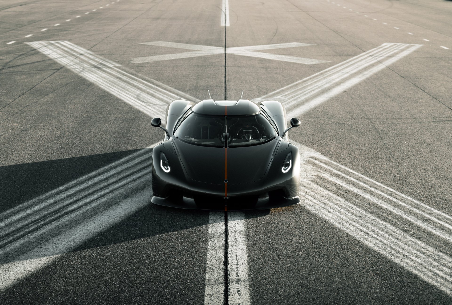 A sleek black Koenigsegg Jesko positioned on a runway, captured in stunning detail for an 8K Ultra HD PC desktop wallpaper and background.