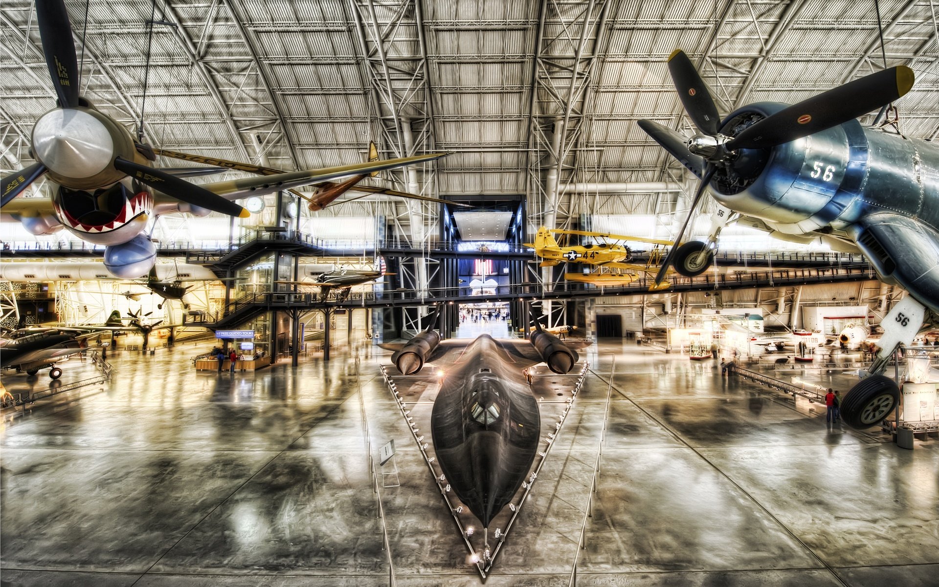 A striking HD wallpaper showcasing military aircraft in a hangar, featuring vintage planes and sleek designs that highlight aviation history and engineering marvels.