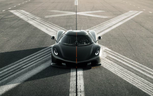A sleek black Koenigsegg Jesko positioned on a runway, captured in stunning detail for an 8K Ultra HD PC desktop wallpaper and background.