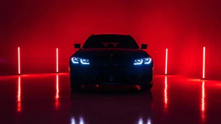 Front silhouette of a BMW M340i Touring with piercing blue headlights against a red-lit studio, 4K Ultra HD PC desktop wallpaper and background.