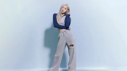 HD desktop wallpaper featuring Rosé from BlackPink posing confidently against a minimalist light blue background, blending music and style seamlessly.
