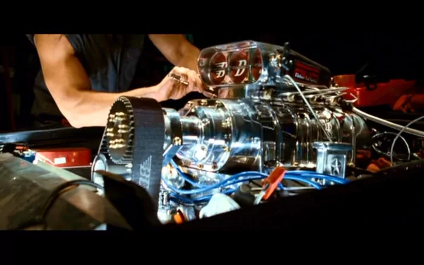 A HD desktop wallpaper featuring a detailed shot of a car engine being worked on, from the Fast & Furious movie series.