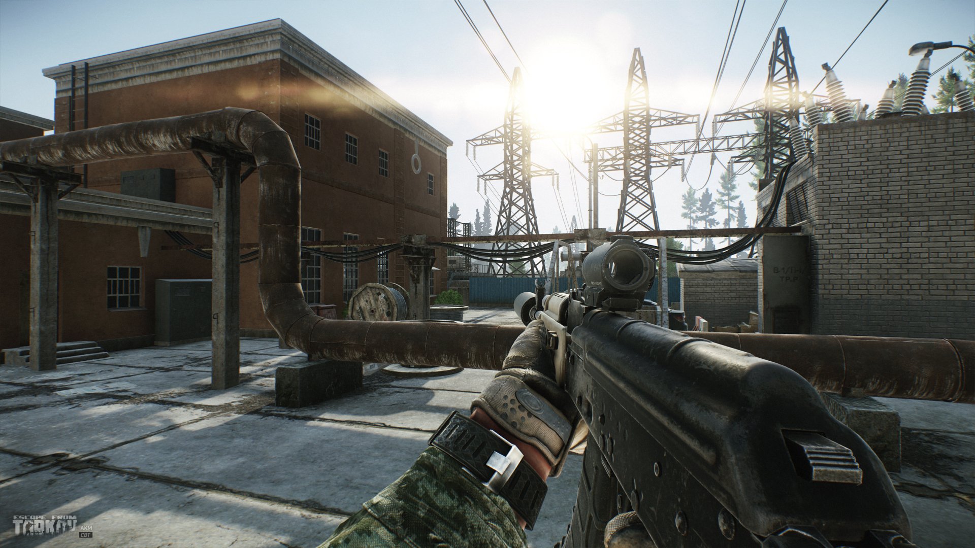 HD Escape From Tarkov desktop wallpaper featuring a first-person view of a player holding a gun in a detailed, sunlit industrial area.