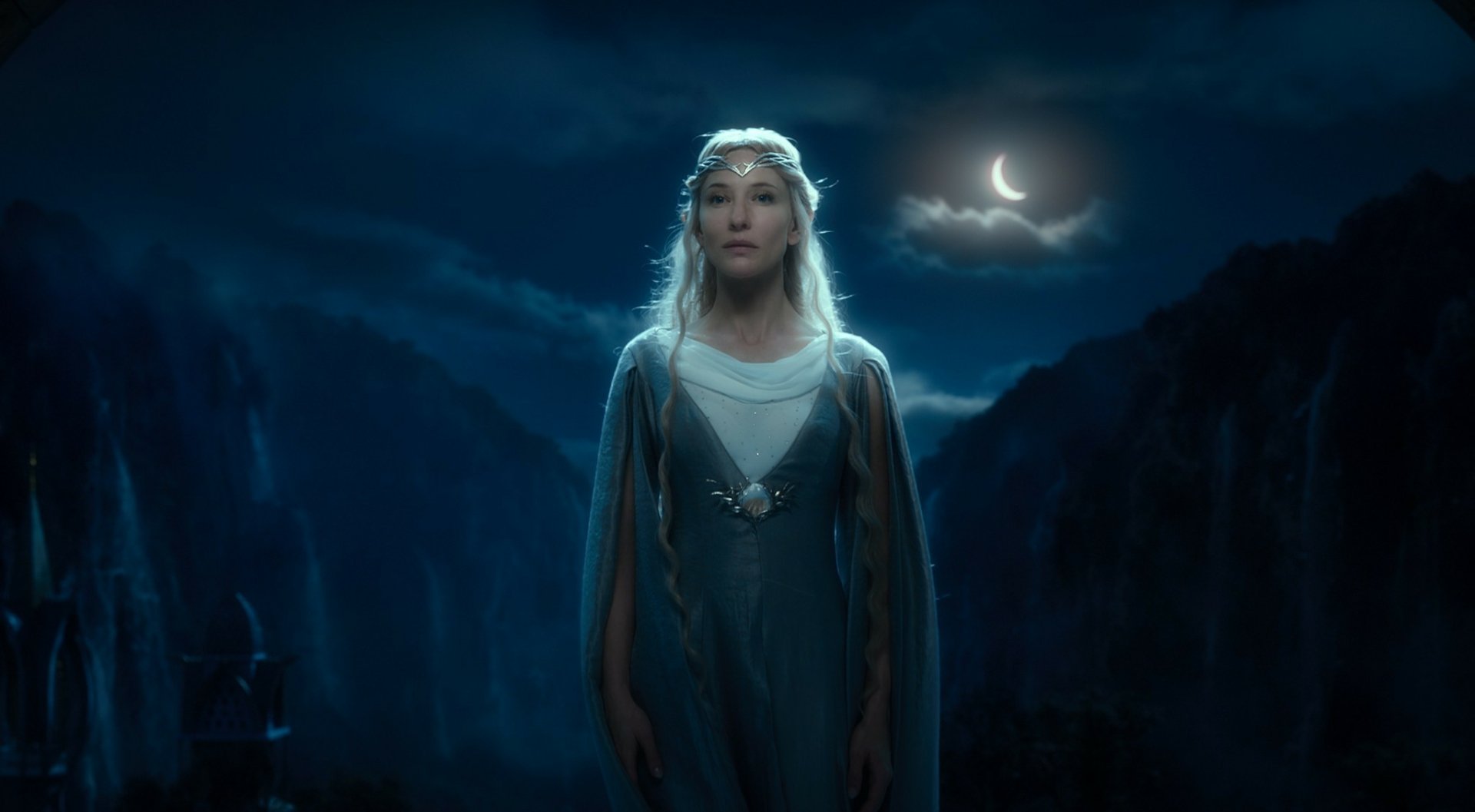 Galadriel from The Lord of the Rings: The Fellowship of the Ring — an ethereal figure in a moonlit gown before jagged peaks, HD PC desktop wallpaper background.
