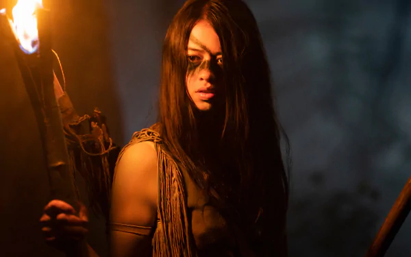 Close-up of a torchlit woman in tribal attire in a dark forest, cinematic still from Prey (2022); 2K Quad HD PC desktop wallpaper background.