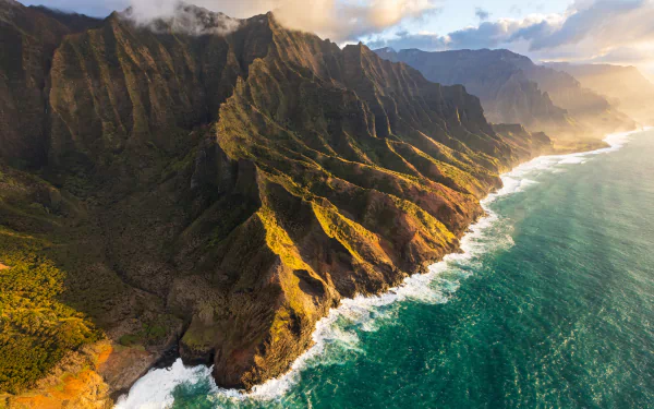 5K Ultra HD PC desktop wallpaper and background: nature coastline with sunlit ridged cliffs and turquoise waves crashing along a rugged shoreline.