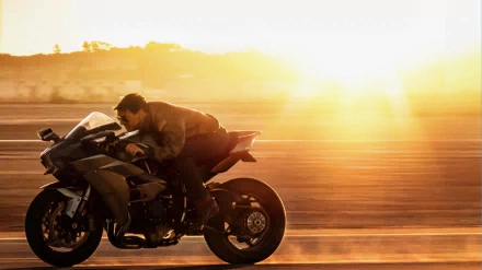 HD PC desktop wallpaper featuring a scene from the movie Top Gun: Maverick with a rider speeding on a motorcycle at sunset.