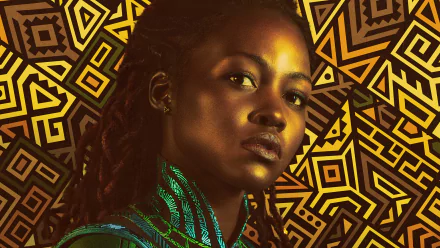 Close-up portrait of Nakia (Marvel Comics) from Black Panther: Wakanda Forever — HD movie desktop wallpaper showing her in green attire against a gold geometric Wakandan pattern.