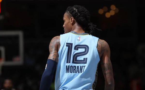 Ja Morant of the Memphis Grizzlies in a dynamic pose, showcasing skill and determination on a vibrant HD desktop wallpaper.