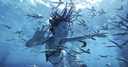 Avatar: The Way of Water character swimming underwater amidst a school of fish in an HD desktop wallpaper.