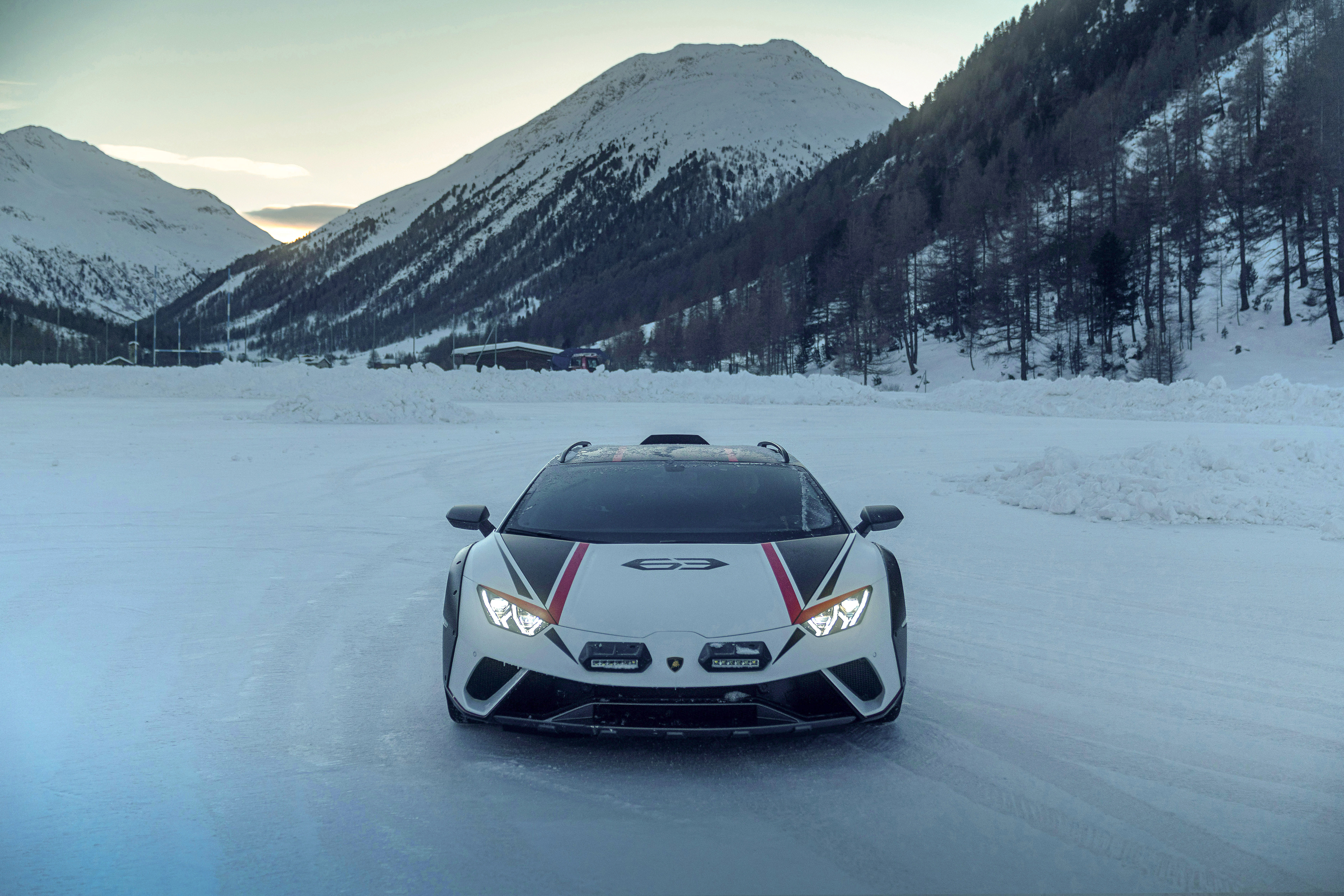 Lamborghini Huracán Sterrato racing across a beautiful landscape in an HD desktop wallpaper.