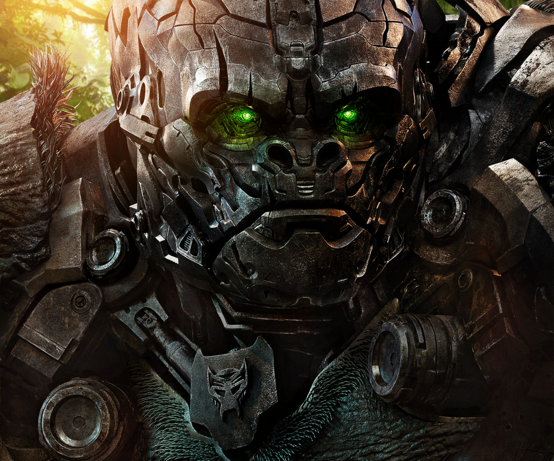 Close-up HD PC desktop wallpaper of a menacing metallic Transformer with glowing green eyes from the movie Transformers: Rise of the Beasts.