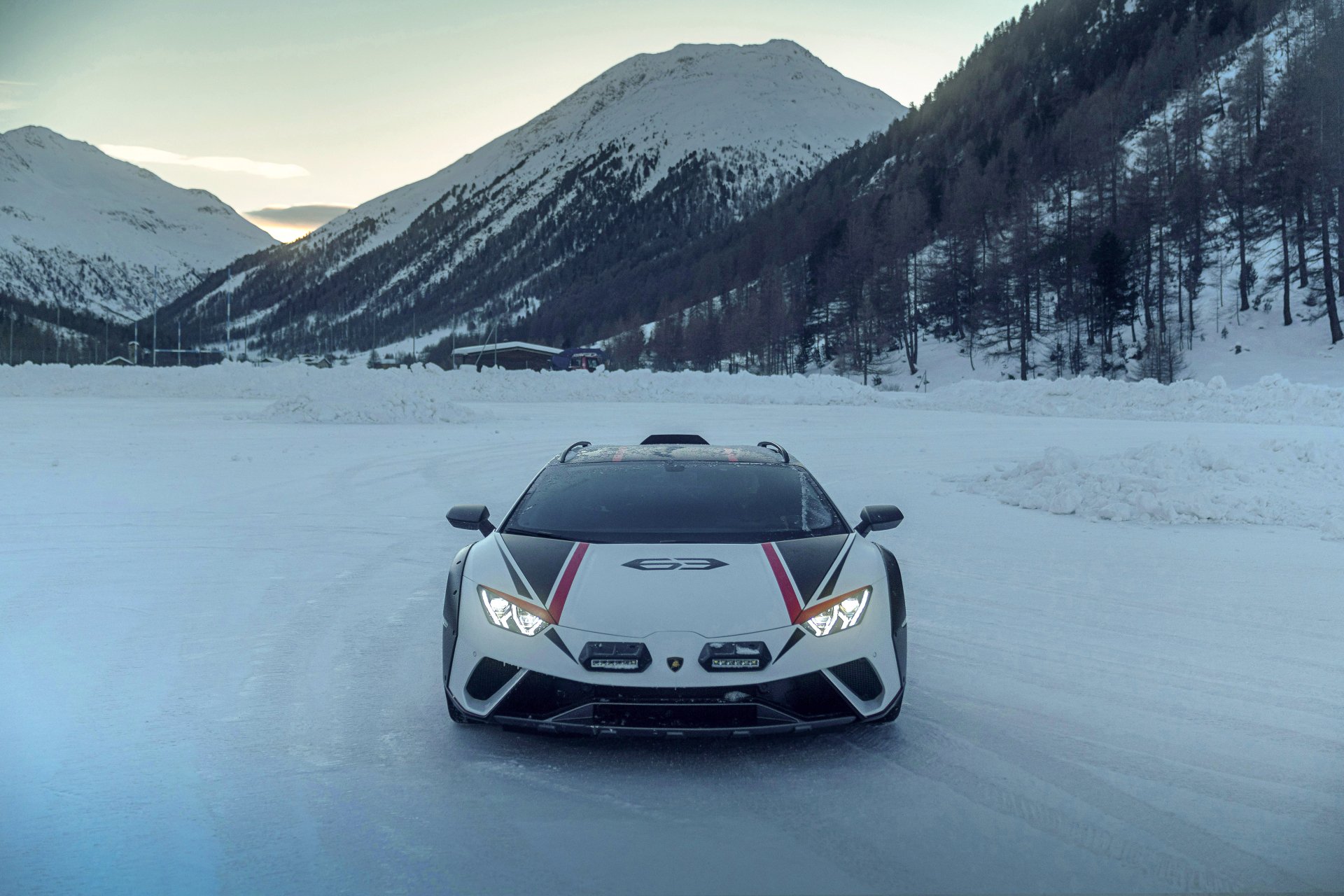 Front view of a white Lamborghini Huracán Sterrato supercar on a snowy mountain road, captured as a 5K Ultra HD PC desktop wallpaper and background.