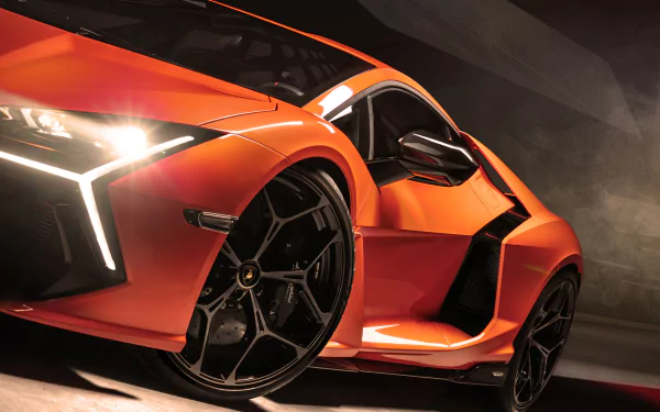 Orange Lamborghini Revuelto vehicle, low-angle close-up in dramatic lighting — high-detail 4K Ultra HD PC desktop wallpaper and background.