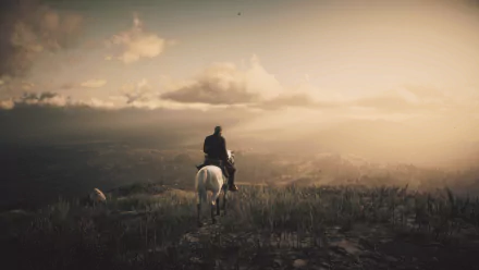 A horseback rider overlooking a mountain landscape at sunset in a high-definition Red Dead Redemption 2 video game PC desktop wallpaper.