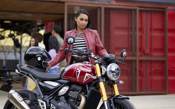 HD desktop wallpaper featuring a person with a Triumph Speed 400 motorcycle, set against an urban backdrop.