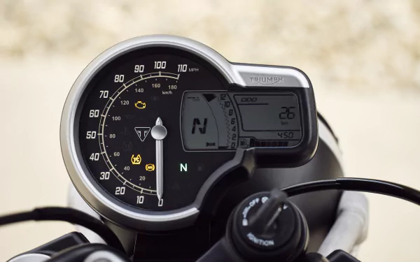 Close-up of the Triumph Scrambler 400 X dashboard, showcasing its speedometer and digital display. This HD image serves as an exciting background for motorcycle enthusiasts.