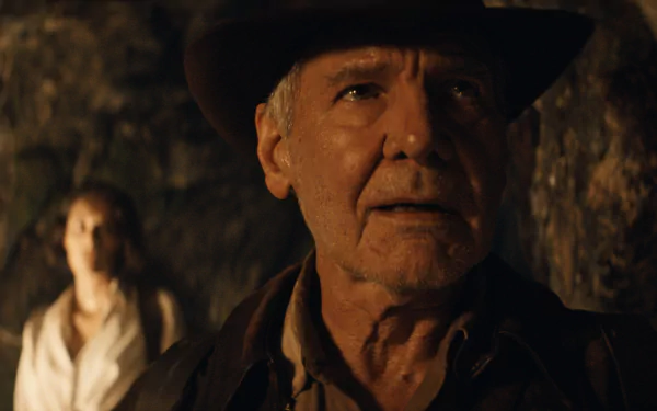 HD desktop wallpaper from Indiana Jones and the Dial of Destiny, featuring Indiana Jones and a companion in a dimly lit cave.