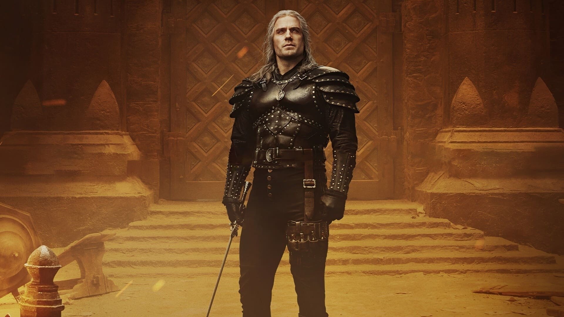 HD PC desktop wallpaper featuring a scene from the TV show The Witcher, showcasing the protagonist in dark armor standing in a grand, dimly lit hall.