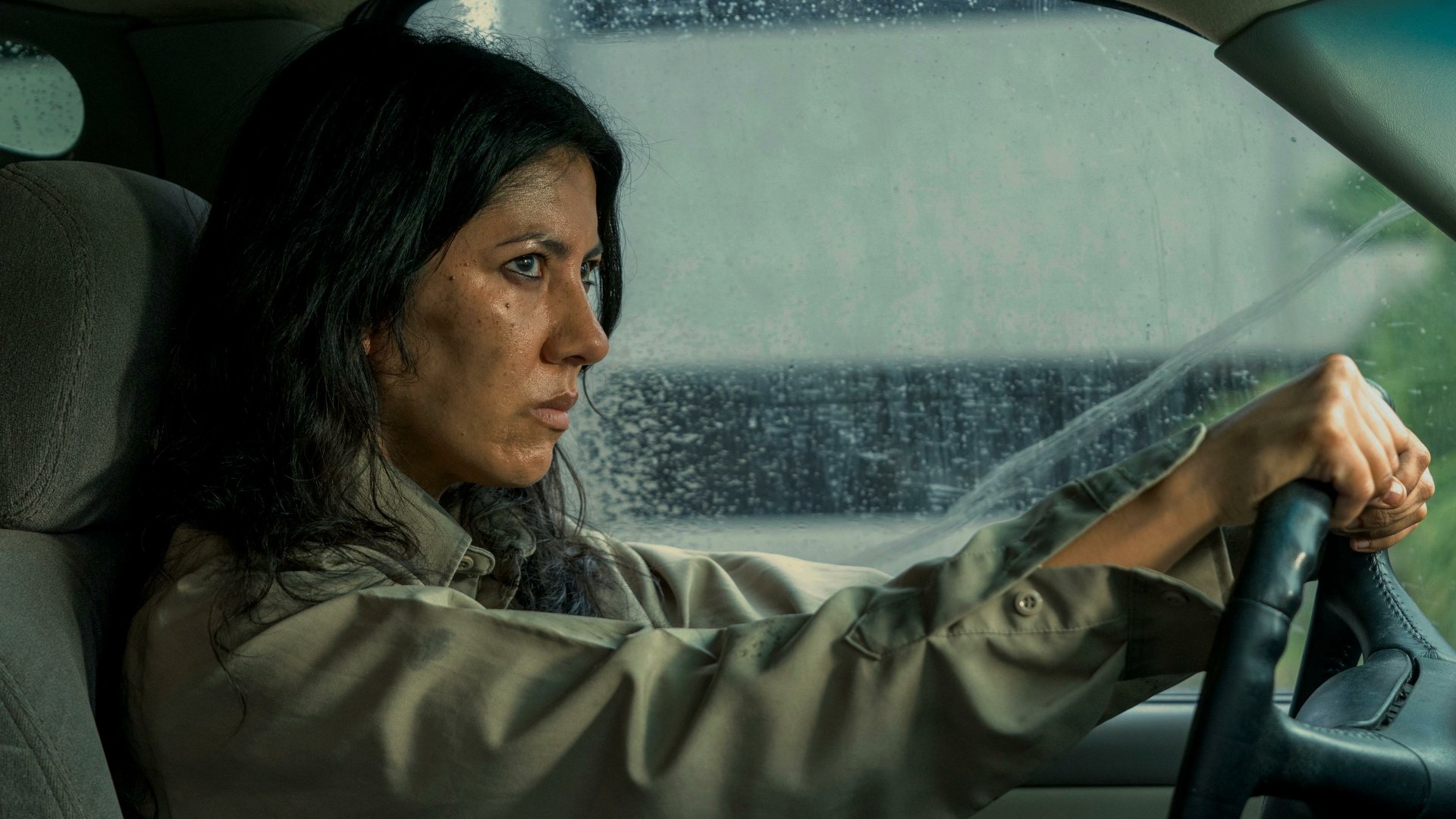 Stephanie Beatriz portrays a determined character in the TV show Twisted Metal, captured in a striking HD wallpaper as she focuses intently while driving through a rain-soaked window.