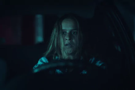 HD desktop wallpaper featuring a tense scene from Black Mirror with a character focused intently while driving at night, reflecting the show's dark and mysterious ambiance.