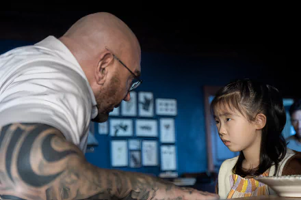 HD desktop wallpaper background with intense scene from Knock at the Cabin, featuring a tattooed man and a young girl in a moment of dialogue.
