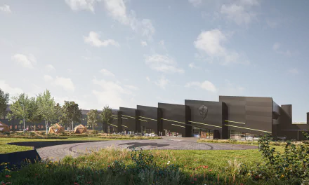 HD desktop wallpaper of the Koenigsegg Gemera at a modern facility, showcasing the sleek design of the building and the surrounding landscaped grounds.