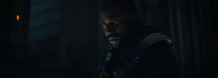 HD wallpaper of John David Washington in a scene from the 2023 movie The Creator, featuring a dimly lit, intense expression.