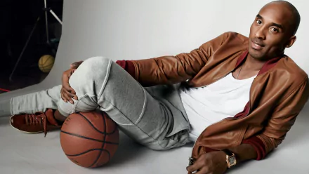 HD desktop wallpaper featuring a basketball player in casual attire reclining with a basketball, suitable as a background image.