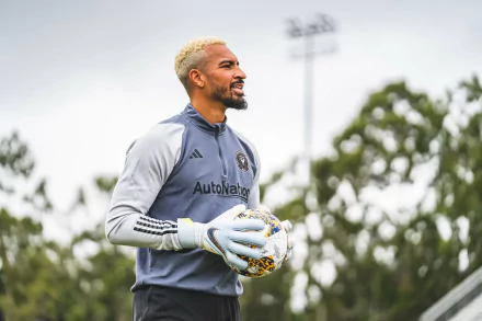 HD wallpaper of an Inter Miami CF goalkeeper, clad in gray, holding a soccer ball on the field.