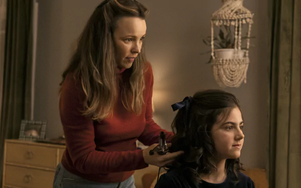 A scene from Are You There God? It's Me, Margaret, featuring a woman styling a girl's hair in a cozy room, serving as a vibrant HD desktop wallpaper and background.