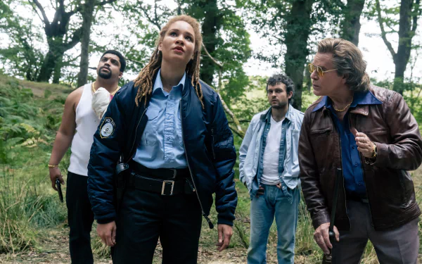 HD wallpaper featuring a scene from the movie Cocaine Bear with four characters looking cautiously through a forest.