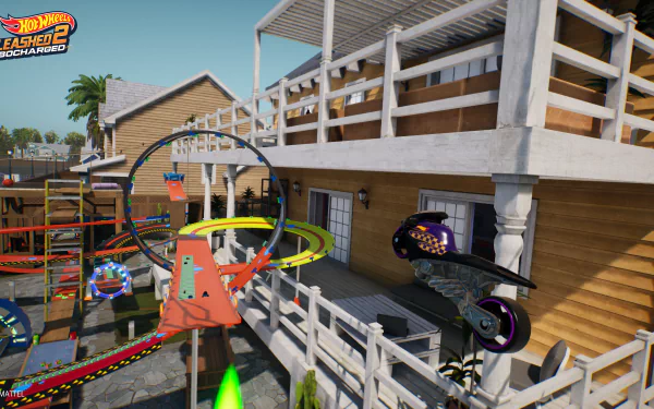 HD desktop wallpaper from Hot Wheels Unleashed 2: Turbocharged, featuring a dynamic race track scene with cars launching through loop-de-loops by a wooden house.
