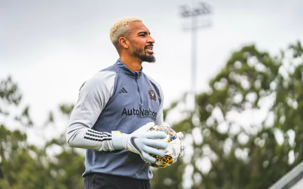 HD wallpaper of an Inter Miami CF goalkeeper, clad in gray, holding a soccer ball on the field.