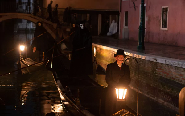 A haunting scene from A Haunting in Venice, featuring a figure in a hat holding a lantern on a darkened canal, with shadowy figures in the background, creating an eerie atmosphere.