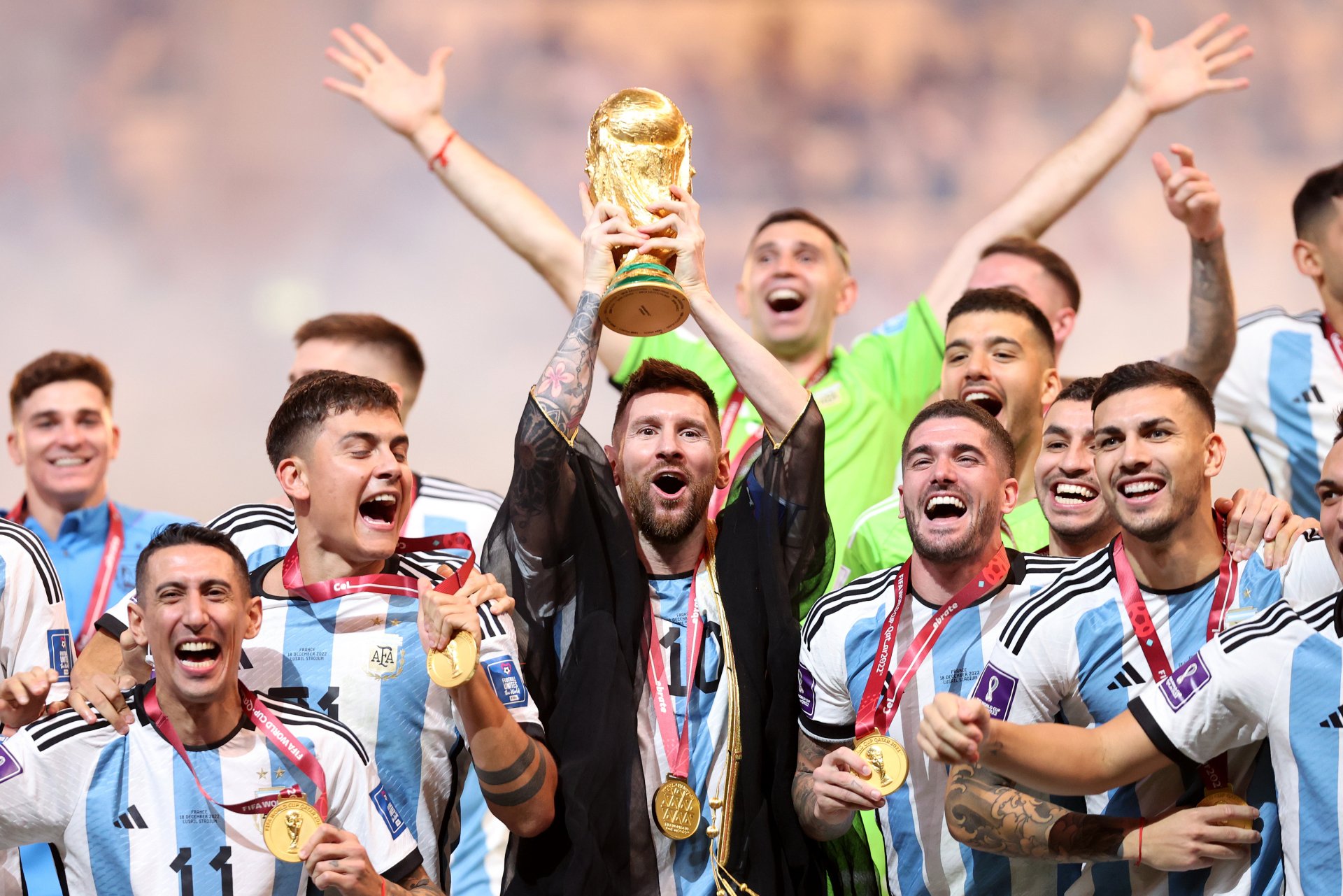 HD desktop wallpaper featuring Lionel Messi, Ángel Di María, and Paulo Dybala celebrating with the Argentina National Football Team holding a trophy.