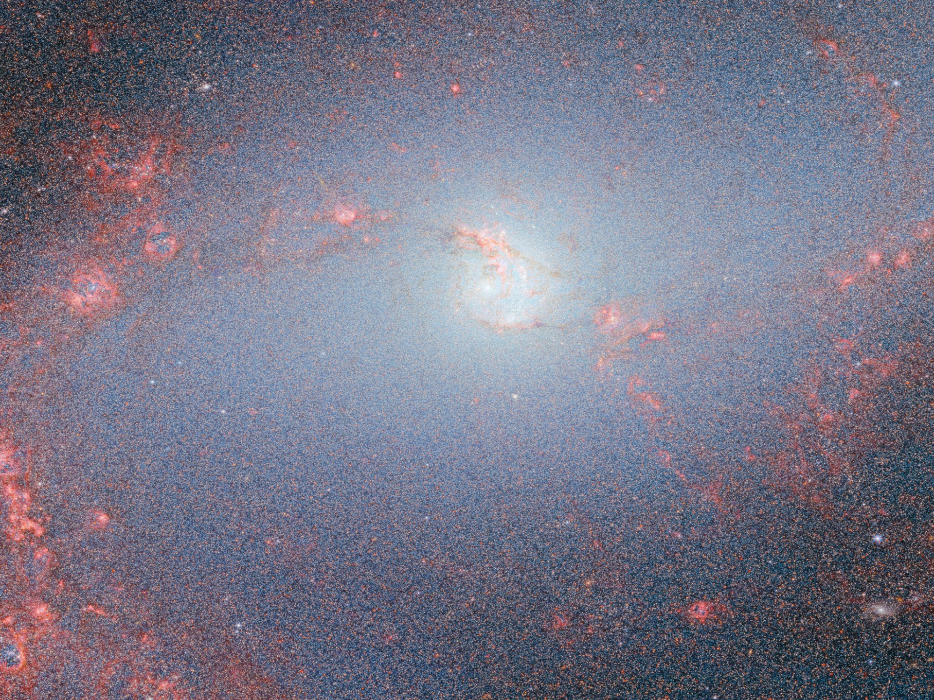 HD desktop wallpaper of a galaxy captured by the James Webb Space Telescope, featuring luminescent galactic core and surrounding star clusters, embodying a sci-fi aesthetic.
