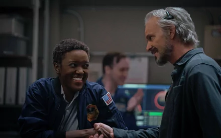 Alt Text: Two astronauts from the TV series 'For All Mankind' sharing a handshake and a smile in a spacecraft control room, set as a high-definition desktop wallpaper and background.