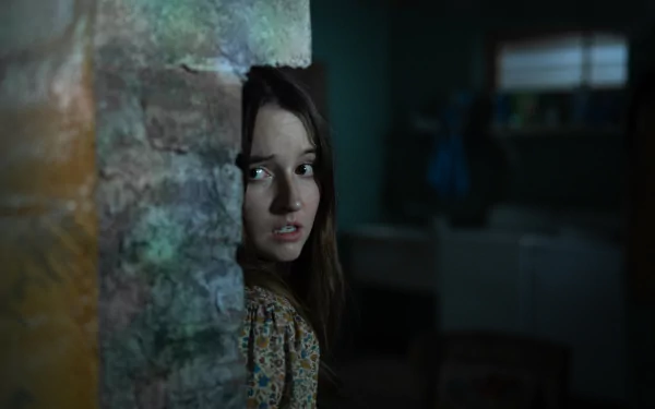 HD desktop wallpaper of Kaitlyn Dever in No One Will Save You looking anxiously around a corner.