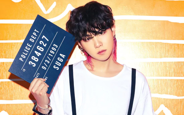 Stylish HD desktop wallpaper featuring a person with a signboard and colorful hair, representing Suga from BTS with a vibrant background.