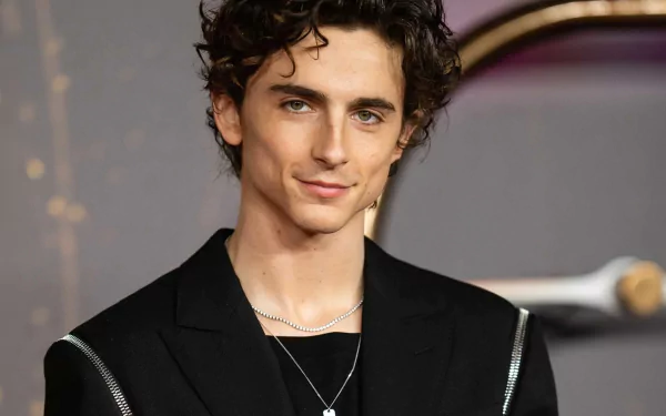 HD desktop wallpaper featuring a poised individual with curly hair, dressed in a black outfit, exuding elegance and confidence.